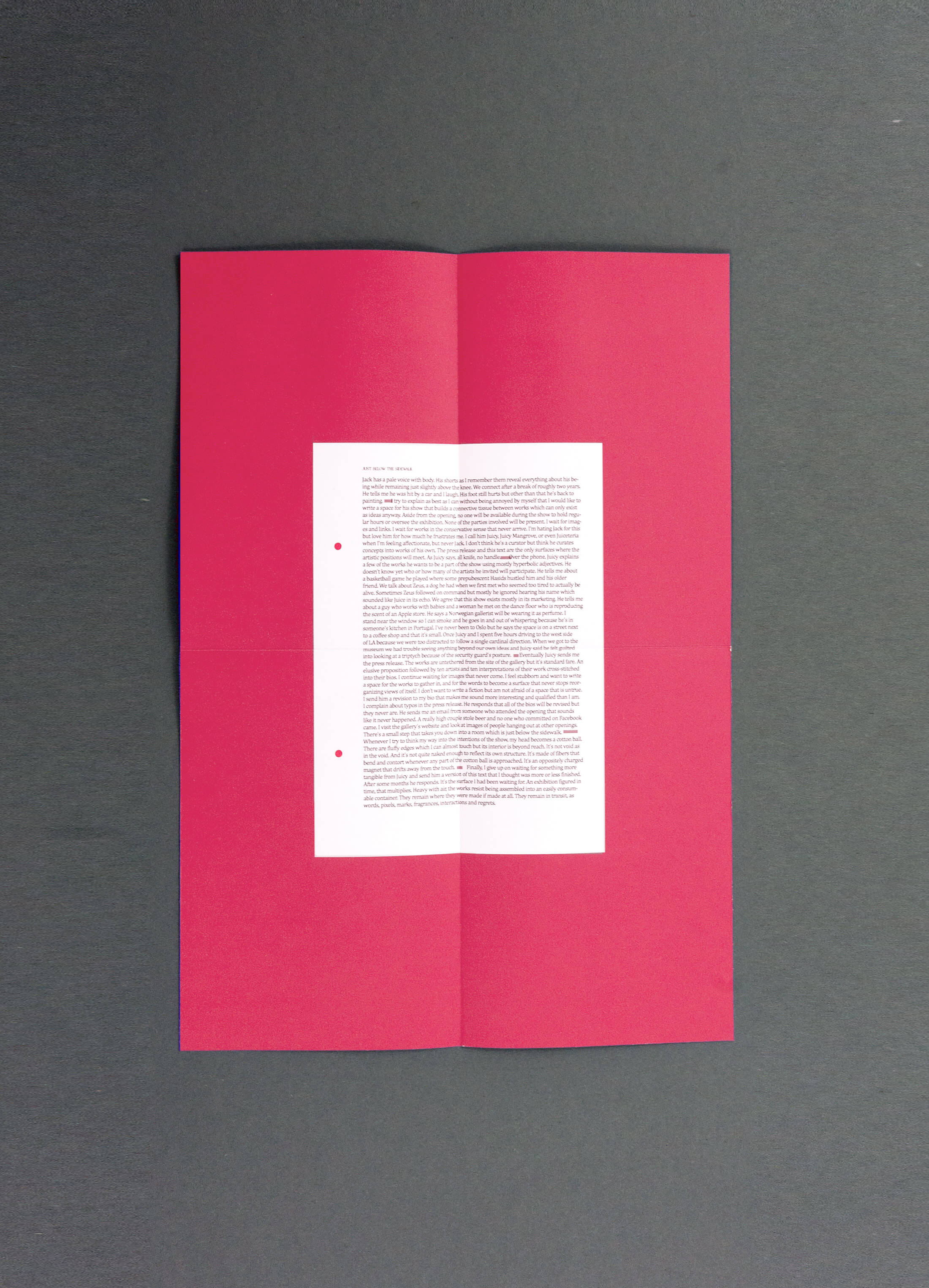 Folded piece of magenta paper with text on printed on it.
